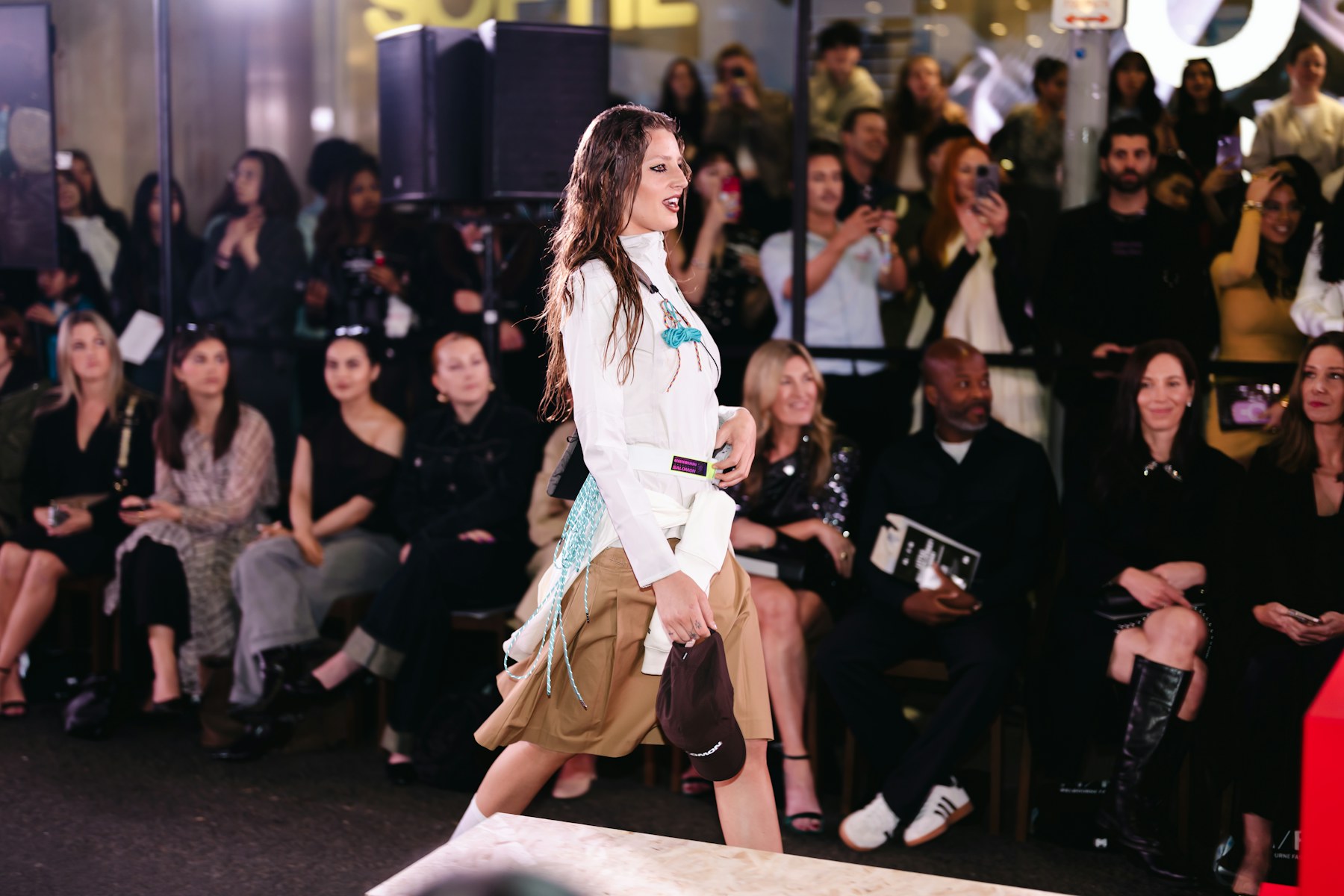 A model walking a runway before an audience